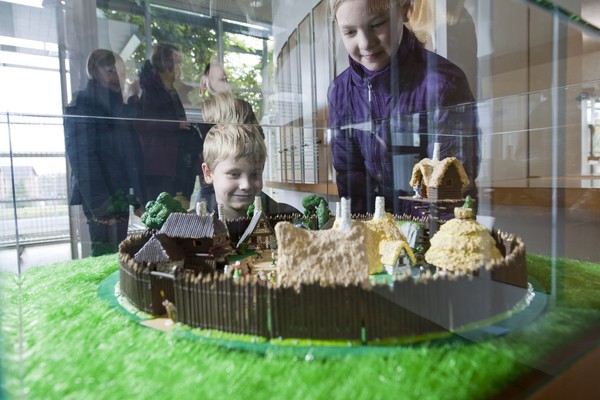 Foto: Zwei Kinder schauen sich das Modell des Gallierdorfs im Foyer des LWL-Römermuseums an.